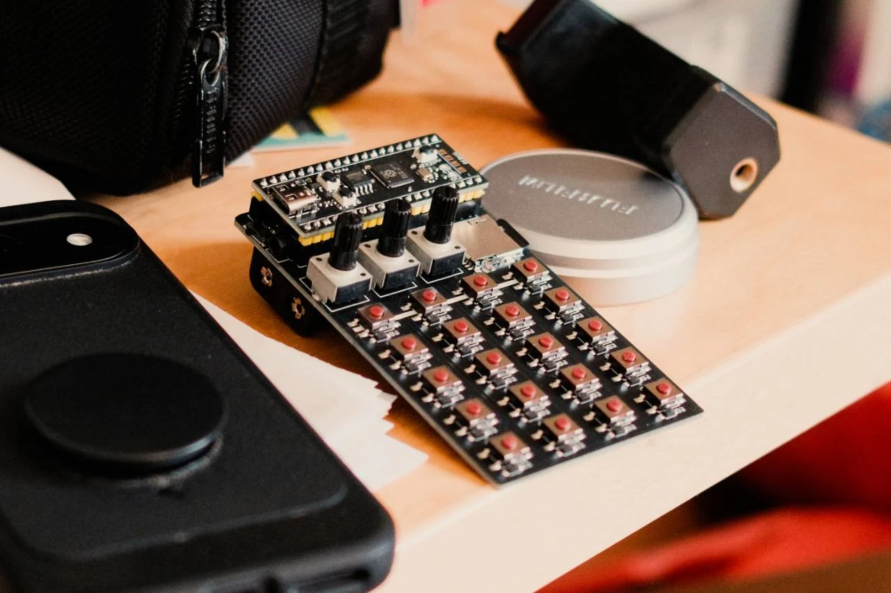 A Zeptocore sampler on a table beside portable music equipment