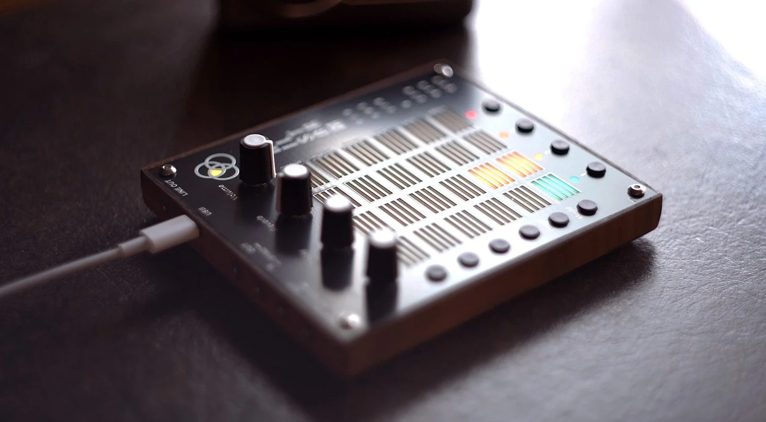 The Hailstorm percussion sequencer illuminated on a dark tabletop