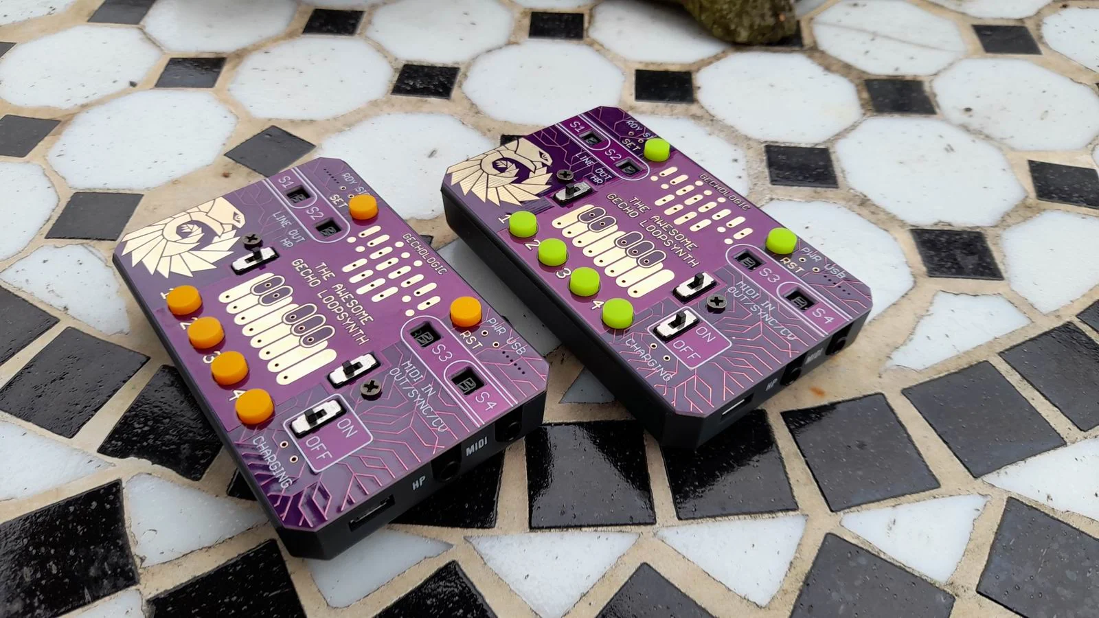 Two brightly colored Gecho Loopsynth instruments on patterned outdoor tiles