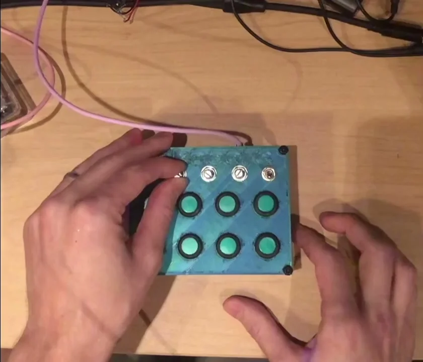 2ononen's compact blue custom Pikocore with eight glowing green buttons and top-mounted switches