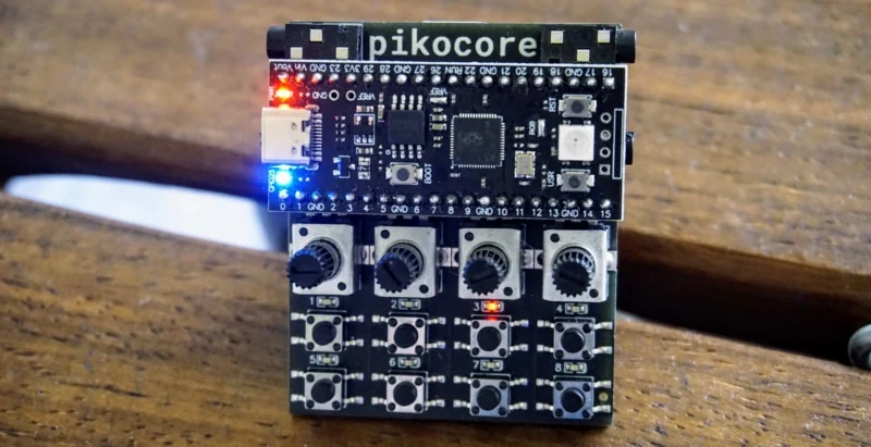 An Infinite Digits Pikocore with its lights on, showing the RP2040 board, four knobs, and eight buttons